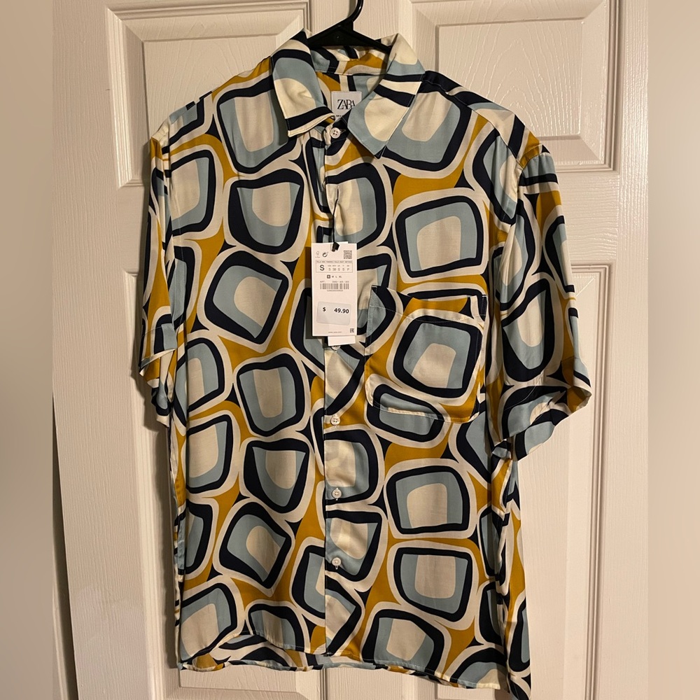 Zara mans sat in short sleeve square, print button down shirt